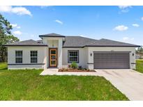 A charming single-story home with a well-maintained lawn and a gray two-car garage at 6421 Sw 151St Loop, Ocala, FL 34473