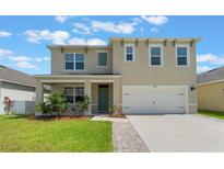 Charming two-story home features a welcoming front porch, two-car garage, and well-manicured lawn at 6808 Cranes Roost Rd, Harmony, FL 34773
