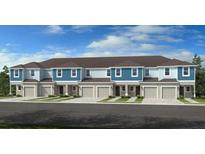 Modern townhome with light blue siding, a brown roof, and individual garages at 7811 Waterscape Dr, Groveland, FL 34736