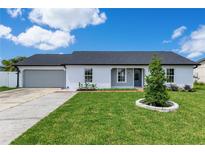 Charming single-story home with white brick, dark roof, and a well-manicured front yard at 8111 Lianna Dr, Orlando, FL 32822