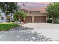 Beautiful two-story home featuring a three-car garage and brick-paved driveway at 8162 Prestbury Dr, Orlando, FL 32832