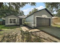 Charming single-story home with a well-maintained front yard and attached two-car garage at 979 Mayfair St, Eustis, FL 32726