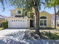 Charming two-story home with a manicured lawn, two-car garage, and classic architectural details at 1111 Liberty Hall Dr, Kissimmee, FL 34746