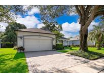 Charming single-Gathering home featuring a two-car garage, lush lawn, and mature trees offering shade at 1173 Valley Creek Run, Winter Park, FL 32792