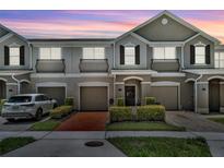 Charming townhome with a well-manicured lawn and inviting front entrance and single car garages at 1191 Honey Blossom Dr # D, Orlando, FL 32824