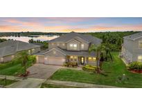 Stunning two-story home with a three-car garage, lush lawn, landscaping, and scenic water view at 16412 Good Hearth Blvd, Clermont, FL 34711
