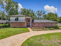 Charming brick home featuring a balcony, arched entryway, and well-manicured lawn at 1850 Lakeshore Cir, Longwood, FL 32750