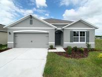 Charming single-story home featuring a two-car garage, neutral tones, and a well-manicured lawn at 1898 Walnut Creek Dr, Kissimmee, FL 34744