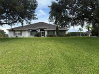 Charming single-story home featuring a well-manicured lawn and mature trees enhancing curb appeal at 23717 Milford Dr, Eustis, FL 32736