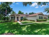 Charming single-story home featuring a well-manicured lawn, inviting walkway, and classic architectural details at 2426 Breezy Meadow Rd, Apopka, FL 32712