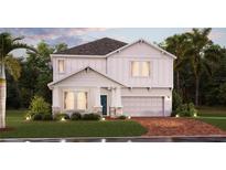 Charming two-story home featuring a manicured lawn, a two car garage, and a welcoming front porch at 2525 Peace Of Mind Ave, Kissimmee, FL 34744