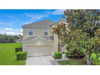 Charming two-story home with a well-maintained lawn and a tree in the front yard at 2669 Manesty Ln, Kissimmee, FL 34747