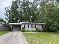 Charming single-story home featuring a carport and a well-maintained front yard at 31538 Anderson Dr, Tavares, FL 32778