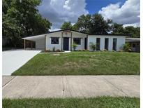 Beautifully renovated single-story home with a manicured lawn and modern carport at 3321 Mahalia Pl, Orlando, FL 32805