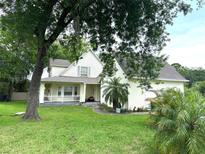 Charming two-story home with a covered front porch and mature trees in a spacious yard at 6230 Cranberry Dr, Port Orange, FL 32127