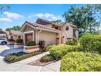 Charming two-story home with a tile roof, manicured landscaping, and an attached garage at 7742 Sugar Bend Dr # 7742, Orlando, FL 32819
