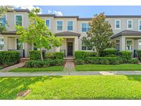 Well-maintained townhouse featuring a landscaped front yard and a welcoming entrance at 9591 Amber Chestnut Way, Winter Garden, FL 34787