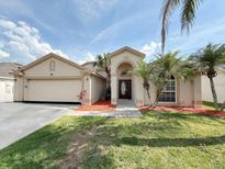 Charming single-story home featuring a well-manicured lawn, beautiful palm trees, and a welcoming front entrance at 14014 Spruce Creek Ln, Orlando, FL 32828