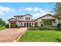 Elegant two-story home with a beautiful brick driveway and well-maintained landscaping at 10630 Mobberley Cir, Orlando, FL 32832