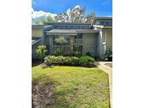 Inviting home featuring a quaint front garden, stone accents, and a second-story balcony at 116 Palm View Ct # 3535/6, Haines City, FL 33844