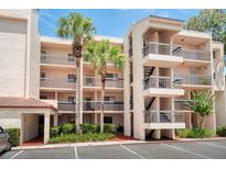 Multi-story condo building featuring balconies, palm trees, and convenient parking at 1166 Carmel Cir # 120, Casselberry, FL 32707