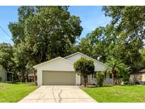 Charming single-story home with a two-car garage and a well-manicured lawn at 142 E 9Th St, Chuluota, FL 32766