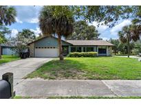 Charming home with a well-manicured lawn, mature landscaping, and a two-car garage at 3220 Cardigan Ct, Orlando, FL 32812