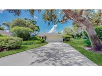 Charming home featuring a well-manicured lawn, lush landscaping, and a long driveway leading to a two-car garage at 42 W Grenewood Ln, Haines City, FL 33844