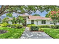 Charming single-story home with manicured lawn, mature trees, and a welcoming front entrance at 6630 Hidden Beach Cir, Orlando, FL 32819