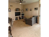 Comfortable living room featuring a ceiling fan and built-in shelves for decor at 7230 Westpointe Blvd # 1235, Orlando, FL 32835
