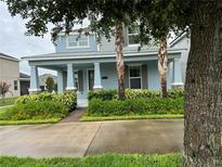 Charming blue two-story home with well-manicured landscaping and a welcoming front porch at 7530 Summerlake Groves St, Winter Garden, FL 34787