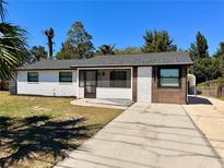 Charming single-story home featuring a mix of brick, wood, and stone exterior accents and a well-maintained front yard at 817 Clay Blvd, Eustis, FL 32726