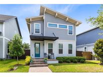 Charming two-story home featuring a blue front door, a covered entry, and well-maintained landscaping at 8290 Nemours Pkwy, Orlando, FL 32827
