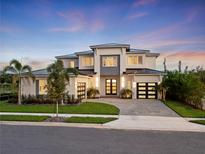 Stunning two-story home featuring a three-car garage, modern design and lush landscaping at 9156 Sheen Sound St, Orlando, FL 32836