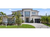 Stunning two-story home with a modern design, lush landscaping, and a paved driveway at 9156 Sheen Sound St, Orlando, FL 32836