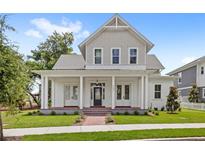 Inviting two-story home with a classic front porch and well-manicured lawn offering great curb appeal at 102 Hammock Preserve Loop, Winter Garden, FL 34787