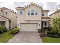 Charming two-story home with a well-manicured lawn and a two-car garage at 1097 Trappers Trail Loop, Davenport, FL 33896