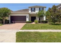 Inviting two-story home with well-manicured lawn, brick driveway, and a two car garage at 1546 Water Elm Ct, Orlando, FL 32825