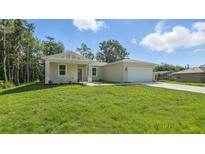 Charming single-story home featuring a spacious front yard and two-car garage at 17 Cypress Run, Haines City, FL 33844