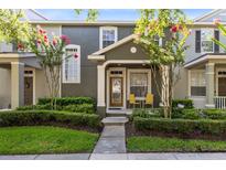 Charming townhome featuring a cozy porch, mature trees, and well-manicured landscaping at 2021 Sweet Birch Ln, Orlando, FL 32828