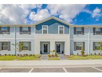 Charming two-story townhome featuring blue and gray siding, a well-manicured lawn, and inviting front entrances at 2438 Dubai St, Kissimmee, FL 34747