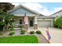 Charming single-Gathering home featuring a well-manicured lawn, stone accents, and a two-car garage at 3142 Dark Sky Dr, Harmony, FL 34773