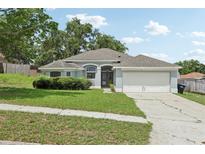 Charming single-story home with a well-manicured lawn, mature landscaping, and attached two-car garage at 3326 Sassaquin Ct, Orlando, FL 32818