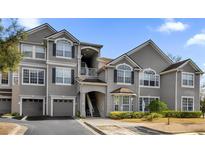 Exterior view of a condominium building with gray siding and arched windows at 3379 S Kirkman Rd # 1027, Orlando, FL 32811