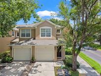 Charming two-story townhome featuring a two-car garage, well-maintained landscaping, and a welcoming entryway at 6453 Alcalde Ct # 110, Orlando, FL 32835