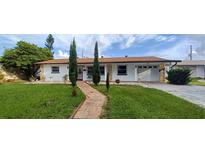 Inviting home with a brick walkway, well-manicured lawn, and attached garage at 10928 Tangora St, Orlando, FL 32825