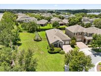 Aerial view showcases a well-maintained home with spacious lawn, mature trees, and pleasing neighborhood at 15500 Fountain Cove Ct, Winter Garden, FL 34787