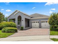 Charming one-story home with a brick driveway, manicured landscaping and a convenient two car garage at 15500 Fountain Cove Ct, Winter Garden, FL 34787