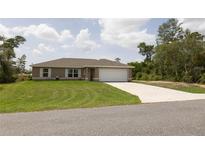 Well-maintained single-story home features a lush lawn, neutral paint, and a two-car attached garage at 16863 Sw 29Th Terrace Rd, Ocala, FL 34473