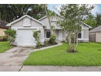 Inviting single-story home with well-maintained lawn, attached two-car garage, and charming landscaping at 1802 Waterbeach Ct, Apopka, FL 32703